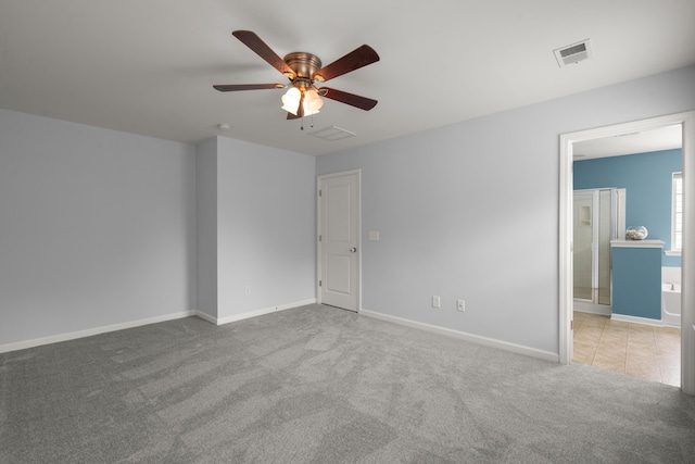 interior space with visible vents, carpet floors, baseboards, ceiling fan, and ensuite bathroom