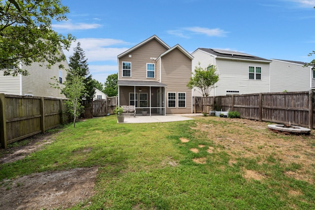 rear view of property featuring a patio area, a fenced backyard, a sunroom, and a yard