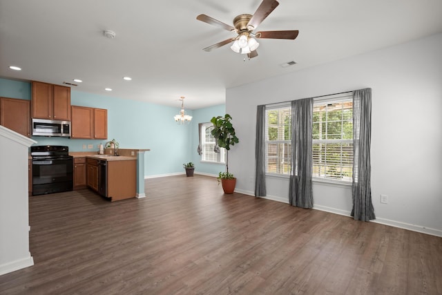 kitchen with a peninsula, dark wood-style floors, stainless steel microwave, visible vents, and black electric range