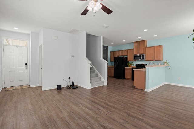 unfurnished living room with baseboards, recessed lighting, and dark wood-type flooring