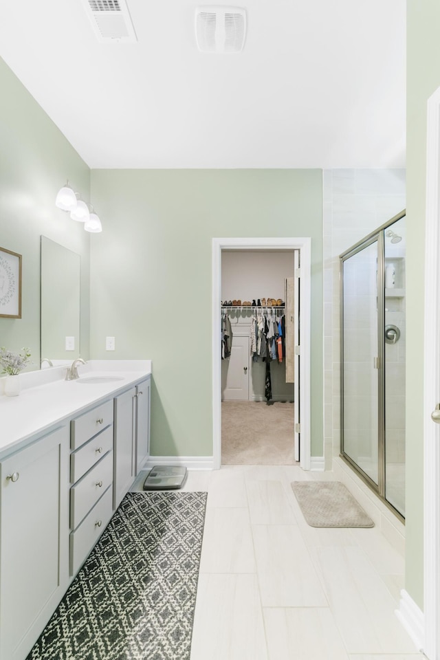 bathroom featuring tile patterned floors, vanity, and walk in shower