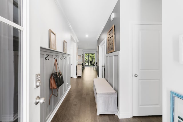 corridor with dark hardwood / wood-style flooring and ornamental molding