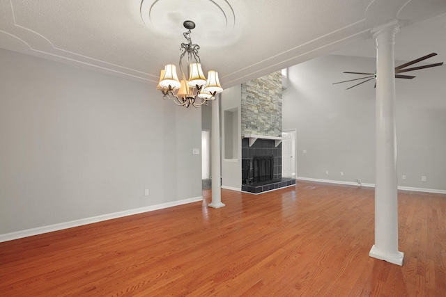105 Londonderry Rd, Goose Creek, SC 29445 - unfurnished living room featuring light wood finished floors, a chandelier, a tiled fireplace, baseboards, and decorative columns