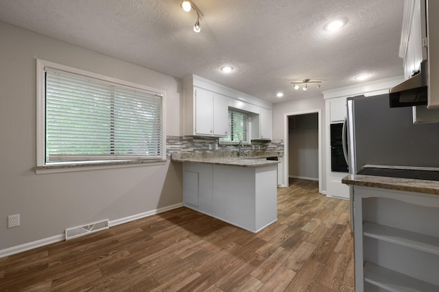 105 Londonderry Rd, Goose Creek, SC 29445 - kitchen featuring a textured ceiling, a peninsula, white cabinets, healthy amount of natural light, and baseboards
