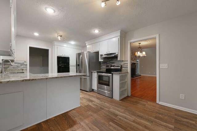 105 Londonderry Rd, Goose Creek, SC 29445 - kitchen featuring black appliances, a sink, decorative backsplash, a peninsula, and a textured ceiling