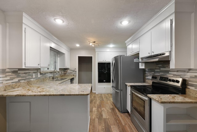 105 Londonderry Rd, Goose Creek, SC 29445 - kitchen featuring stainless steel appliances, under cabinet range hood, a sink, a textured ceiling, and a peninsula