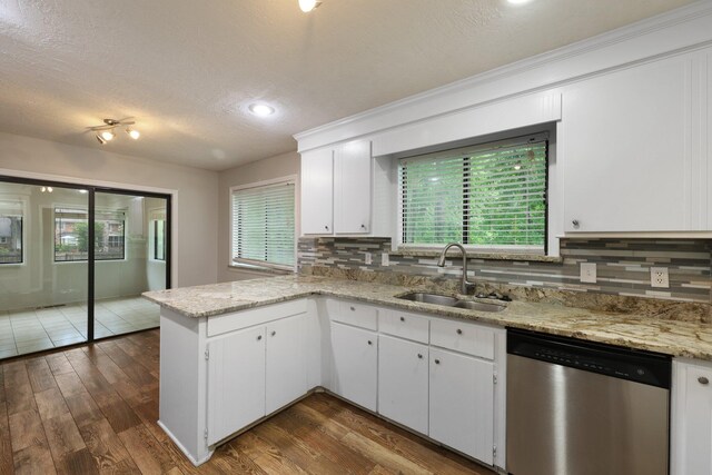105 Londonderry Rd, Goose Creek, SC 29445 - kitchen with stainless steel dishwasher, a sink, a peninsula, decorative backsplash, and white cabinets