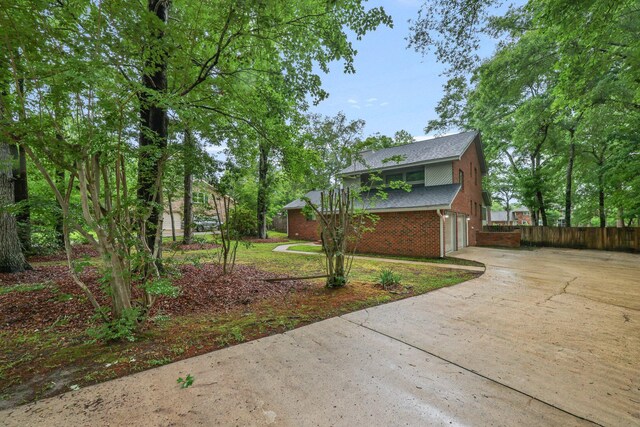 105 Londonderry Rd, Goose Creek, SC 29445 - view of home's exterior with concrete driveway, brick siding, fence, a garage, and roof with shingles