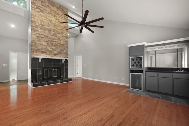 105 Londonderry Rd, Goose Creek, SC 29445 - unfurnished living room with high vaulted ceiling, a ceiling fan, wood finished floors, a fireplace, and a sink