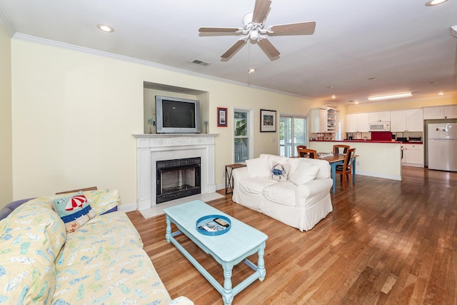 2613 Rivertowne Pkwy, Mount Pleasant, SC 29466 - living area featuring a fireplace with flush hearth, ornamental molding, wood finished floors, a ceiling fan, and recessed lighting