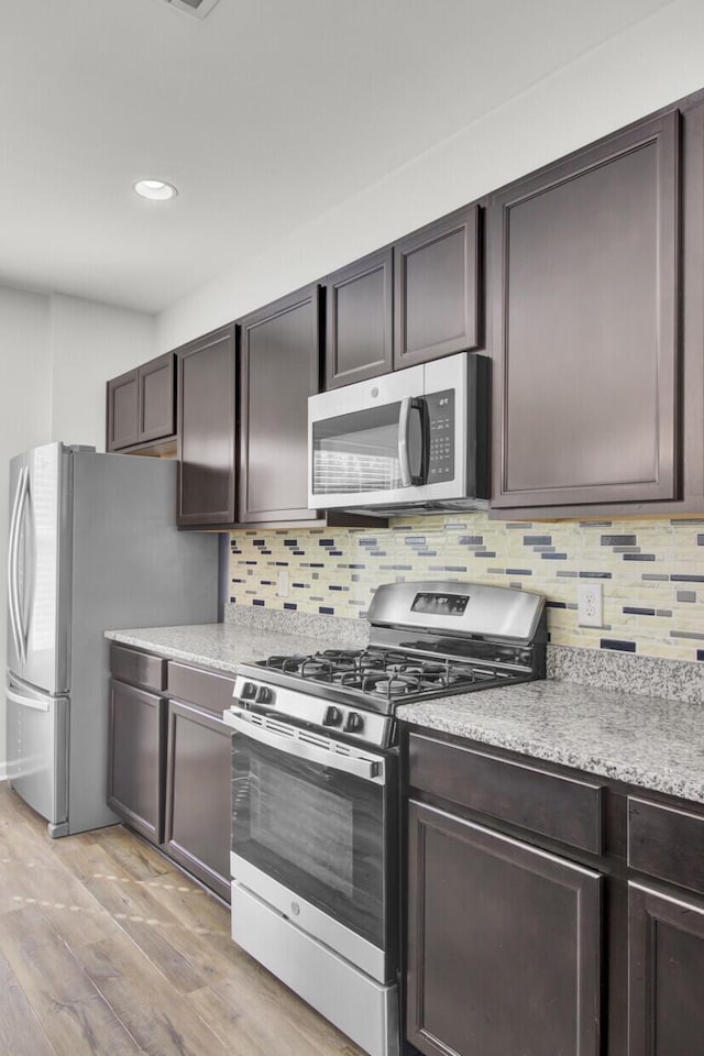 kitchen with light hardwood / wood-style floors, dark brown cabinets, and stainless steel appliances