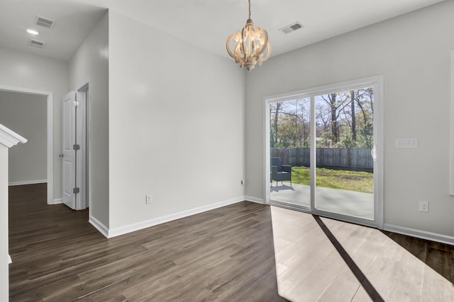 unfurnished room featuring dark hardwood / wood-style flooring and a chandelier