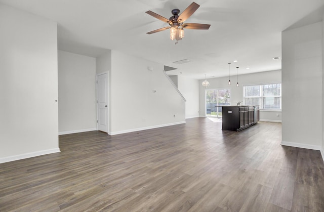 unfurnished living room featuring ceiling fan, dark wood-type flooring, and sink