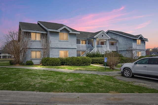 view of front of home with stairway and a front lawn