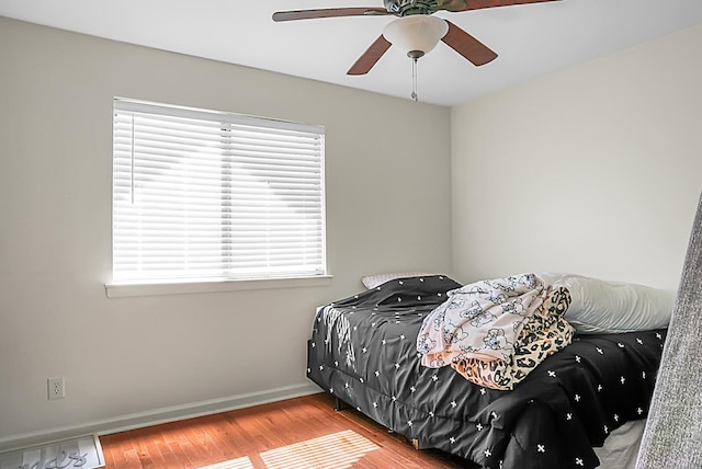 bedroom with ceiling fan, baseboards, and wood finished floors