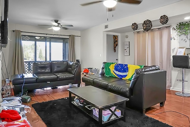 living room featuring visible vents, ceiling fan, and wood finished floors