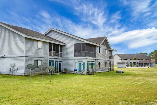 rear view of property with a yard and a sunroom