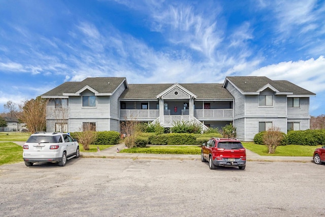 view of front of property featuring uncovered parking and a front yard