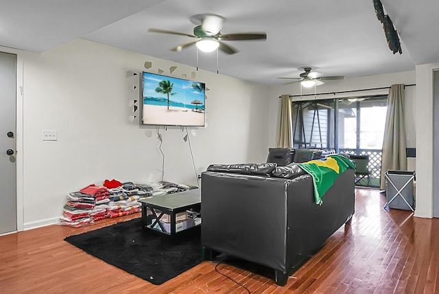 living room featuring wood finished floors, a ceiling fan, and baseboards