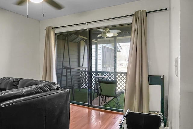 living area with wood finished floors and a ceiling fan