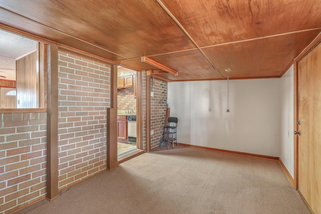 below grade area featuring baseboards, brick wall, crown molding, wooden ceiling, and carpet flooring