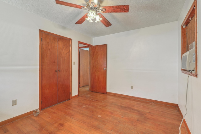 unfurnished bedroom with baseboards, wood finished floors, a closet, and a textured ceiling