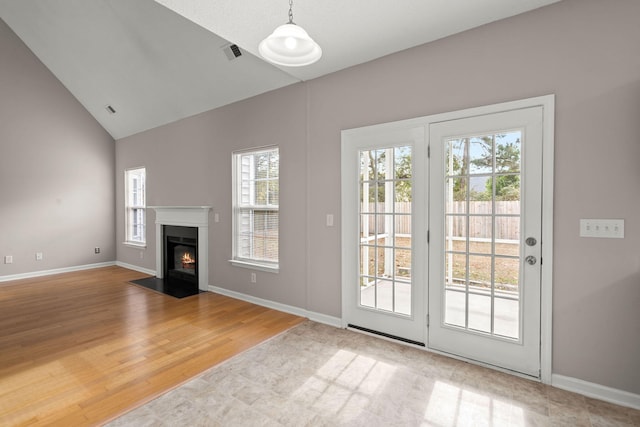 unfurnished living room with wood-type flooring and lofted ceiling