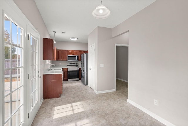 kitchen featuring sink, stainless steel appliances, and decorative light fixtures