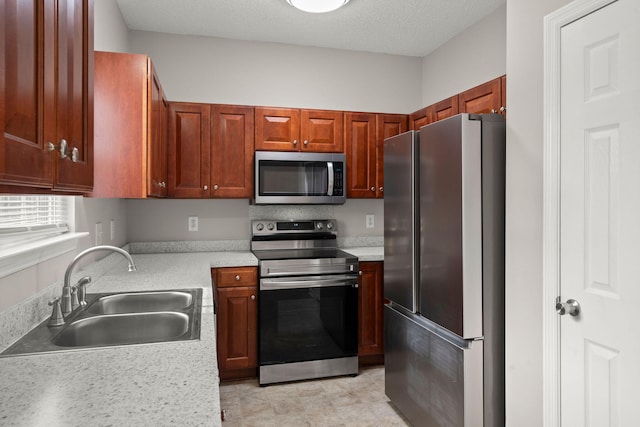 kitchen featuring sink, a textured ceiling, and appliances with stainless steel finishes