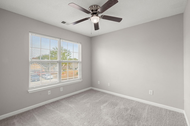 empty room featuring carpet flooring, ceiling fan, and a textured ceiling