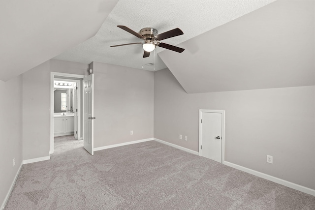 bonus room featuring a textured ceiling, ceiling fan, light carpet, and vaulted ceiling