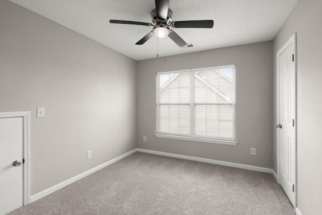 unfurnished room featuring carpet, ceiling fan, and a textured ceiling