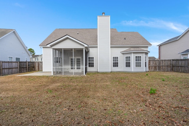 back of property with a patio, a lawn, and a sunroom