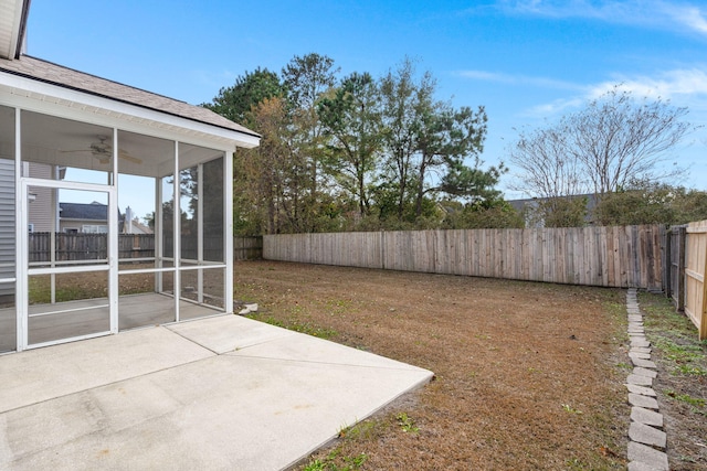 view of yard featuring a patio area, ceiling fan, and a sunroom