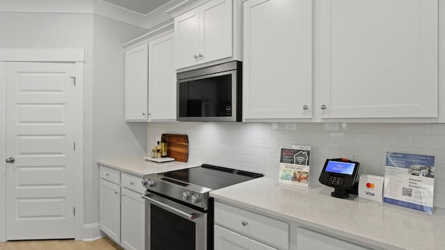212 Bilge Rd, Ridgeville, SC 29472 - kitchen featuring appliances with stainless steel finishes, white cabinets, light stone countertops, and decorative backsplash