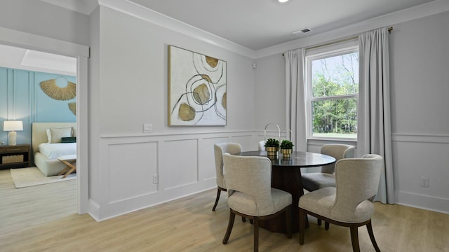 212 Bilge Rd, Ridgeville, SC 29472 - dining space featuring a decorative wall, light wood-style floors, and wainscoting
