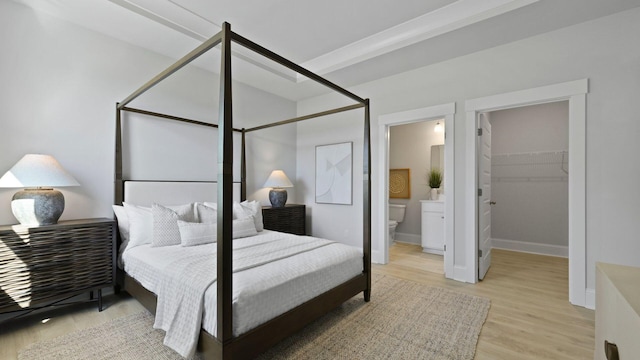 212 Bilge Rd, Ridgeville, SC 29472 - bedroom featuring wood finished floors, a walk in closet, ensuite bath, and baseboards