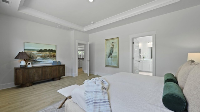 212 Bilge Rd, Ridgeville, SC 29472 - bedroom featuring light wood-type flooring, baseboards, a raised ceiling, and connected bathroom
