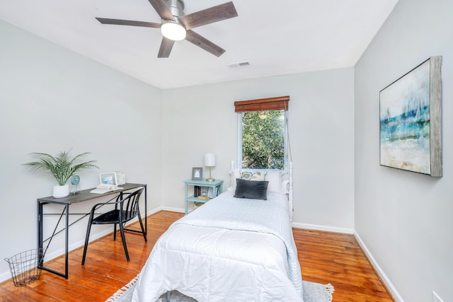 bedroom featuring visible vents, baseboards, and wood finished floors