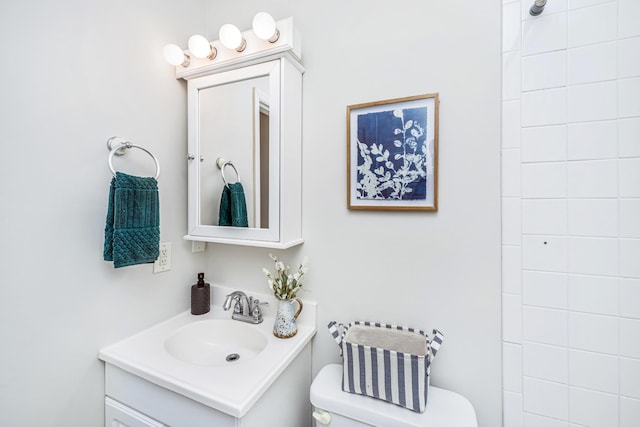 full bath featuring toilet, tiled shower, and vanity