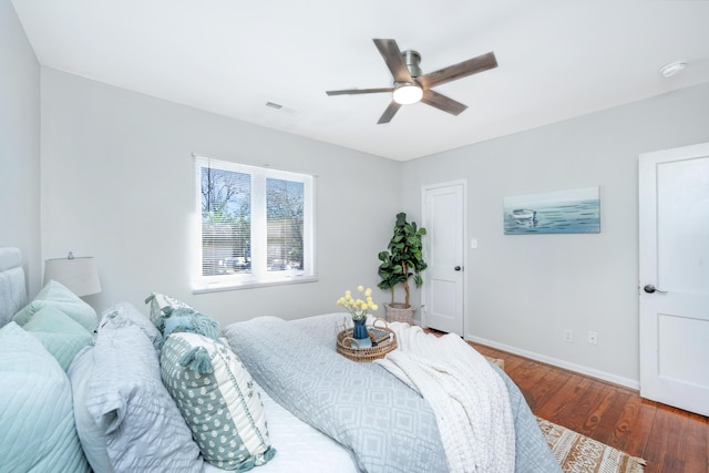 bedroom with baseboards, visible vents, ceiling fan, and wood finished floors