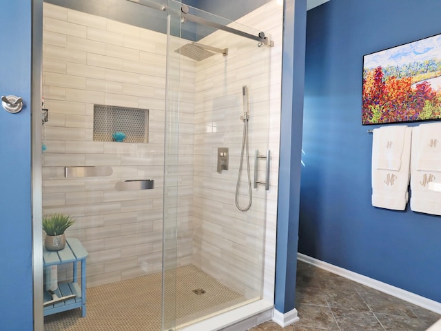 bathroom featuring a shower stall and baseboards