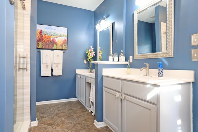 full bath with a shower, vanity, and baseboards