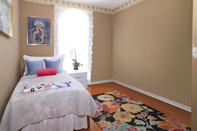 bedroom with baseboards and wood finished floors