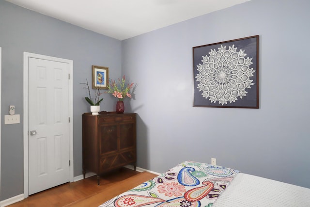 bedroom featuring baseboards and wood finished floors