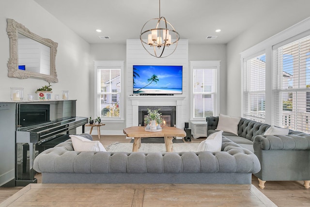 living area with visible vents, a fireplace, baseboards, and wood finished floors