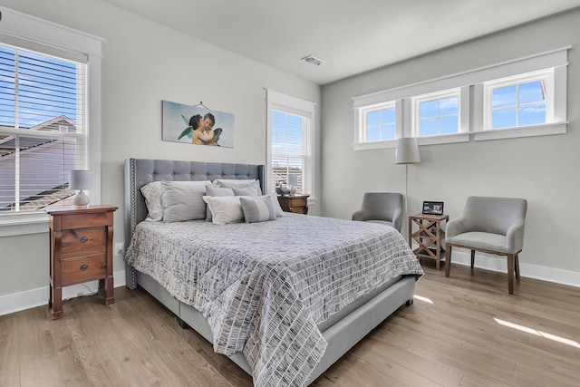 bedroom with visible vents, baseboards, and light wood-style flooring