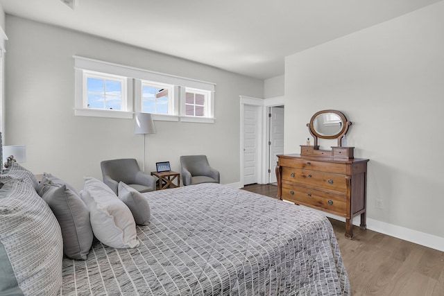 bedroom with wood finished floors and baseboards