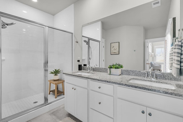 bathroom with a shower stall, visible vents, and a sink