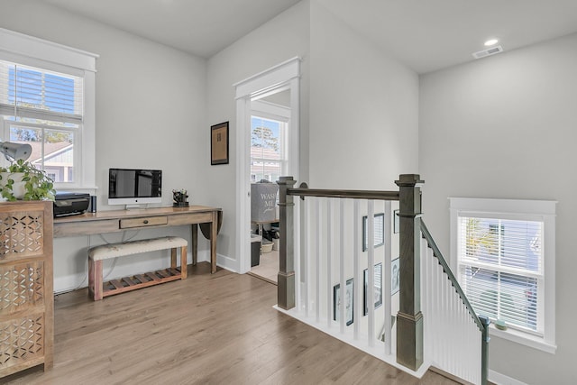 home office featuring visible vents, a healthy amount of sunlight, baseboards, and wood finished floors